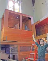  ??  ?? Photo shows music director Cody Mead points to where organ pipes have been removed from in front of the stained glass windows in the choir loft of St Mary’s Church.