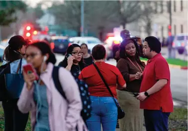  ?? Houston Chronicle via AP ?? ■ People wait Tuesday outside Bellaire High School after a shooting in Bellaire, Texas.