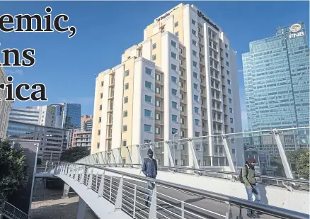  ?? BLOOMBERG ?? Pedestrian­s use a footbridge alongside the Southern Sun Hotel, operated by Tsogo Sun Hotels Ltd, in Cape Town on Aug 19.