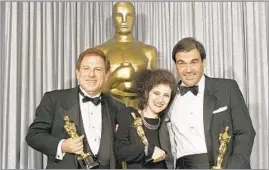  ?? Lennox McLendon Associated Press ?? ‘A MAN OF INCREDIBLE PASSION’ Producer Arnold Kopelson, left, editor Claire Simpson and director Oliver Stone celebrate their Oscars for the 1986 Vietnam War drama “Platoon.”
