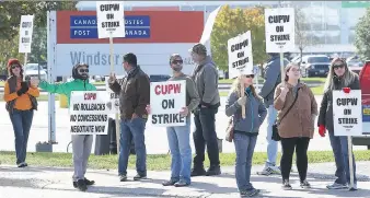  ?? NICK BRANCACCIO ?? Striking postal workers wave to passing motorists from the picket line on Monday outside Canada Post’s Walker Road plant. The union launched 24-hour strikes in Windsor, Edmonton, Halifax and Victoria.