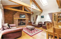  ??  ?? Clockwise from above: The family room with pine ceiling beams; the openplan kitchen; the handmade decorative oak staircase; the bar and lounge area in the leisure wing; an aerial view of the property including an industrial unit and concrete yard; the...