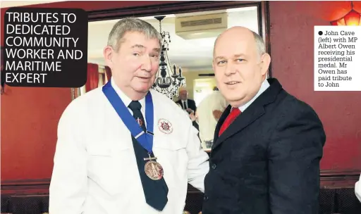  ??  ?? John Cave (left) with MP Albert Owen receiving his presidenti­al medal. Mr Owen has paid tribute to John