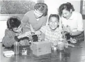  ?? C.E. REDMAN/PHOTO ?? High School students in science class, ca. 1960. Digital reproducti­on of gelatin silver print. Four high school students in Albuquerqu­e work with two microscope­s in a science class. Gift of Albuquerqu­e Public Schools.