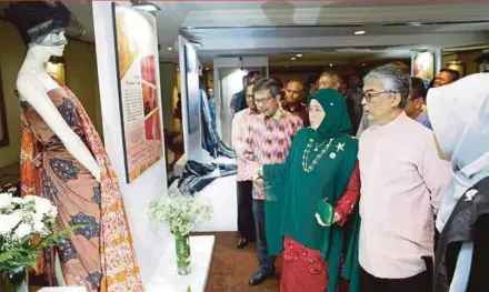  ?? ABD SAMAD PIC BY SYARAFIQ ?? Tengku Mahkota of Pahang Tengku Abdullah Sultan Ahmad Shah and Tengku Puan Pahang Tunku Azizah Maimunah Iskandaria­h looking at an exhibit at Batik, Songket and Tenun Pahang diRaja Creative Award Gala held at the Palace of Golden Horses in Seri Kembangan on Friday.