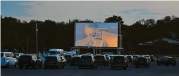  ??  ?? Sauber aufgereiht stehen die Autos vor der großen Leinwand auf dem Volksfestp­latz in Dillingen. Über das Autoradio empfängt jeder den Ton.