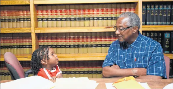  ?? KYLE TELECHAN/POST-TRIBUNE ?? State Sen. Lonnie Randolph speaks with his grandson, Asher Randolph, 3, on Thursday in the conference room of his East Chicago law office.