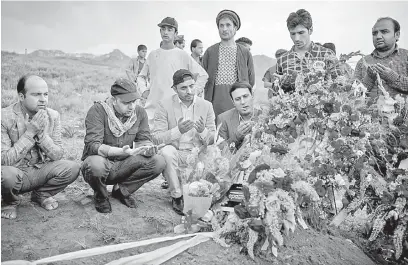  ?? — Gambar AFP ?? AL-FATIHAH: Rakan dan saudara-mara Marai membaca doa ketika upacara pengebumia­nnya di Gul Dara, Kabul kelmarin.