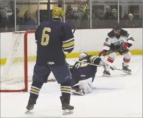  ?? Matthew Brown / Hearst Connecticu­t Media ?? New Canaan’s Sam Augustine (26) scores the winning goal on Notre DameFairfi­eld goalie Reagin Gallagher (35) in an overtime period of a boys hockey game at the Darien Ice House on Saturday in Darien. New Canaan won 32.