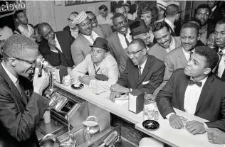  ?? Bob Gomel ?? Malcolm X snaps a photograph of Cassius Clay — soon to become Muhammad Ali — on Feb. 25, 1964, in Miami, after the boxer’s win over Sonny Liston. The moment was captured for Life magazine by photograph­er Bob Gomel.