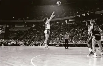  ?? Mark Junge / Getty Images 1976 ?? Denver Nuggets guard Monte Towe shoots from beyond the 3-point line during an ABA game against the San Antonio Spurs in 1976, years before the NBA adopted the extra-point shot.