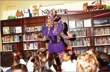  ?? AMY LOMBARD/THE NEW YORK TIMES ?? Harmonica Sunbeam warms up her audience during Drag Queen Story Hour in the Hudson Park branch of the New York Public Library, April 27.