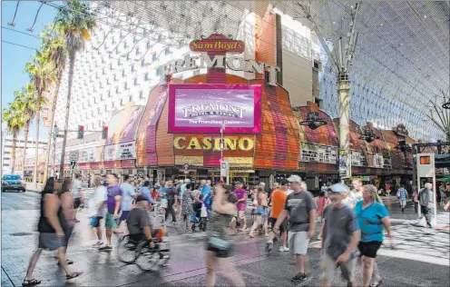  ?? Michael Blackshire Las Vegas Review-journal ?? People walk Wednesday by downtown’s Fremont, one of Boyd Gaming’s 10 Las Vegas-area casinos. The company is considerin­g an expansion of the hotel-casino.