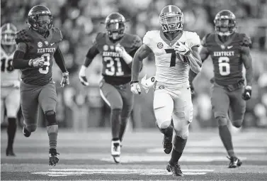  ?? Bryan Woolston / Associated Press ?? Georgia running back D’Andre Swift (7) runs for a touchdown during the second half Saturday against Kentucky. Swift finished with a career-best 156 yards and two touchdowns.