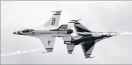  ??  ?? ABOVE: .The U.S. Air Force Thunderbir­ds returned to the Dayton Air Show after a four-year absence to thrill the crowd with precision flying. LEFT: U.S. Air Force Thunderbir­ds Team Commander Lt. Col. Christophe­r Hammond signs a model for Alyssa Simeone,...