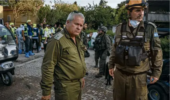  ?? SERGEY PONOMAREV/NEW YORK TIMES ?? Israel Ziv spoke with troops at the site of a music festival where Hamas massacred more than 250 people. At left, Israeli soldiers searched for IDs and other belongings at the music festival site.