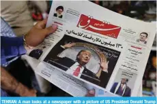  ??  ?? TEHRAN: A man looks at a newspaper with a picture of US President Donald Trump on the front page in the capital yesterday. — AFP