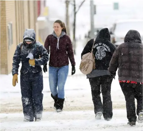 ??  ?? Women walk through the snowy streets of downtown Fort St. John last month. The city of about 21,000 in northeaste­rn B.C. has an economy tied to natural resou