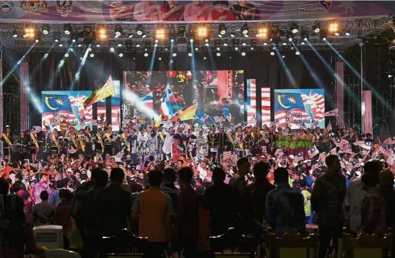  ??  ?? Performers waving the Jalur Gemilang and the state flags of Sabah and Sarawak onstage during the Malaysia Day 2018 celebratio­n in Kota Kinabalu. — Photos: Bernama