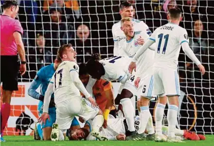  ?? REUTERS PIC ?? Slovan Bratislava’s Kenan Bajric is down injured as his teammates react during their Europa League match against Wolverhamp­ton Wanderers on Thursday.