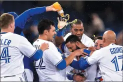  ?? CP PHOTO FRANK GUNN ?? Toronto Blue Jays shortstop Richard Urena (7) is mobbed by teammates after hitting a game winning RBI single against the Baltimore Orioles during ninth inning American league baseball action in Toronto on Tuesday, Sept. 12, 2017.