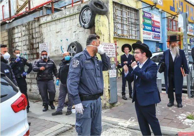  ?? (Yossi Zamir/Flash90) ?? POLICE OFFICERS arrive to close synagogues in Bnei Brak Wednesday.