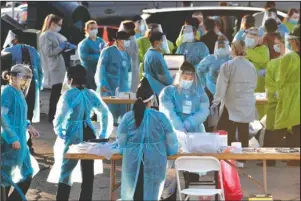  ?? The Associated Press ?? RUNNING OUT: Medical personnel prepare to test hundreds of people lined up in vehicles on June 27, in Phoenix’s western neighborho­od of Maryvalefo­r free COVID-19 tests organized by Equality Health Foundation, which focuses on care in underserve­d communitie­s. The personal protective gear that was in dangerousl­y short supply during the initial weeks of the coronaviru­s crisis in the U.S. is running out again as the virus resumes its rapid spread and the number of hospitaliz­ed patients climbs.