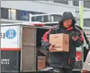  ?? XINHUA SUN FANYUE / ?? A courier delivers parcels during a cold snap in Tianjin on Dec 12.