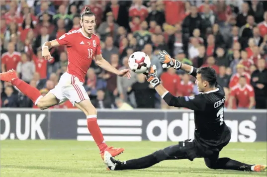  ?? PICTURE: REUTERS ?? WELSH WIZARD: Gareth Bale scores Wales’s third goal against Moldova during last night’s World Cup European Zone qualifier in Cardiff.