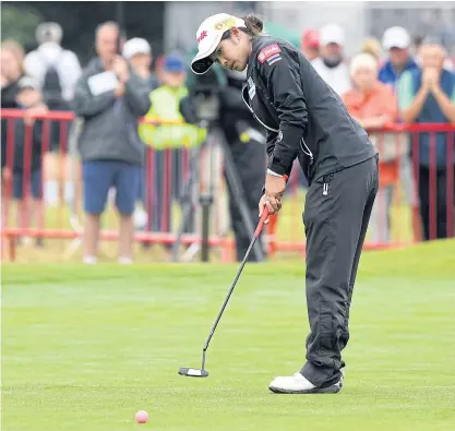  ??  ?? Pornanong Phatlum makes a putt on the 18th green in the second round of the Women’s British Open.