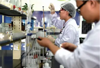  ??  ?? 伊利集团检测人员在液­态奶生产基地中心化验­室对生产线上的产品进­行实时化验检测（任军川/摄）