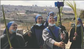  ?? (AP/Mahmoud Illean) ?? Nuns pose for a selfie as they mark Palm Sunday on the Mount of Olives in Jerusalem. A year after coronaviru­s restrictio­ns halted mass gatherings, Christians are celebratin­g Holy Week together.