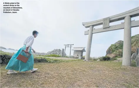  ??  ?? A Shinto priest at the ancient shrine on the mountain of Okinoshima, an island in Fukuoka Prefecture, Japan.