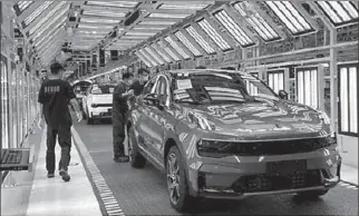  ?? NINGBO CITY
-AFP ?? Employees wearing face masks following the coronaviru­s disease outbreak work on a Lynk & Co car production line at Geely's Yuyao plant in Ningbo city, Zhejiang province, China.