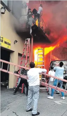  ?? ILKER KESIKTAS THE ASSOCIATED PRESS ?? Girls flee a second-story dance studio onto a balcony as a fire engulfs their building in Edgewater, N.J. About 15 girls were treated for minor injuries, mayor Michel Joseph McPartland said. “I had trouble sleeping last night. It was crazy,” said Ilker...