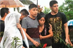  ??  ?? Amigos. La lluvia no fue obstáculo para que compañeros y amigos de iglesia de Julio César asistieran al entierro al cementerio general de Nahuizalco.