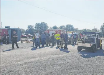  ?? Jeff Long The Associated Press ?? Emergency responders set up a staging area near Teutopolis High School on Saturday in Teutopolis, Ill. Federal regulators are reviewing the crash.