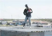  ?? Pictures: Supplied ?? LIFESAVER. A metro police officer yesterday caught a baby girl hurled from a roof by her father during an eviction operation in Joe Slovo Township, Port Elizabeth.