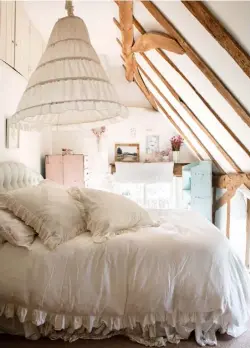  ??  ?? BEDROOM
Top A romantic flounced lampshade crowns Belle’s bed like a coronet canopy. The rugs and bedlinen are mainly from Shabby Chic Above An artistic mix on Belle’s bedroom mantelpiec­e includes a Norwegian portrait