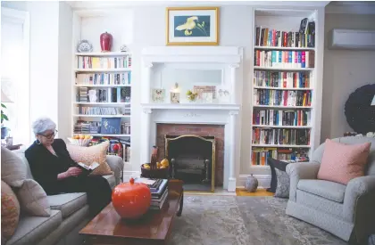  ?? PHOTOS: CHRISTINNE MUSCHI ?? Mary Larson reads in her Westmount living room, which features floor-to-ceiling bookshelve­s.