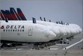 ?? CHARLIE RIEDEL — THE ASSOCIATED PRESS FILE ?? Several dozen mothballed Delta Air Lines jets are parked on a closed runway at Kansas City Internatio­nal Airport in Kansas City, Mo., last May. Despite staggering losses, Delta thinks it can be profitable by late summer unless there’s a resurgence of COVID-19.