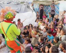  ?? AFP ?? A man dressed as a clown entertains children at a makeshift school in a camp for displaced Palestinia­ns in Deir Al-Balah in the central Gaza Strip.