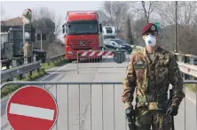  ?? EPA ?? A soldier stands guard at a roadblock at the entrance to the small, quarantine­d village of Vo Euganeo in northern Italy