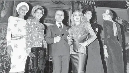  ?? Pierre Guillaud AFP/Getty Images ?? KEEPING IT HAUTE AND FRESH Karl Lagerfeld with Jerry Hall, third from right, in 1984. Every season he translated street styles and social trends into Chanel clothes.