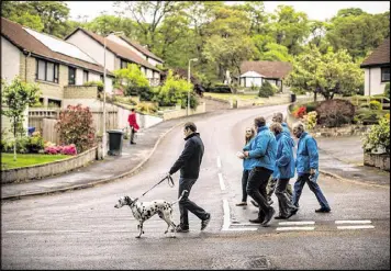  ?? MATTHEW LLOYD / BLOOMBERG ?? Douglas Ross, candidate for the Moray region for the Scottish Conservati­ves Party, left, campaigns with supporters in Forres, Scotland, on May 15.