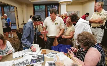  ?? Gerald Herbert / Associated Press ?? Lester Hollenback, left, of Deltona, Fla., a surviving member of the famed World War II Army unit Merrill’s Marauders, talks with visitors as they look over memorabili­a in New Orleans on Tuesday.