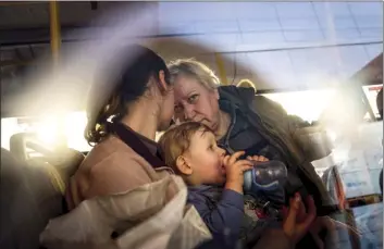  ?? AP photo ?? People with children wait after arriving from the Ukrainian city of Mariupol at a center for displaced people in Zaporizhzh­ia, Ukraine on Tuesday.