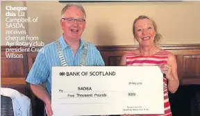  ??  ?? Cheque this Liz Campbell, of SASDA, receives cheque from Ayr Rotary club president Craig Wilson