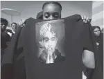  ?? AP PHOTO/BRYNN ANDERSON ?? Anneyah Lawson, 14, of St. Petersburg, Fla., holds up a sweatshirt with an image of slain rapper XXXTentaci­on, before his memorial Wednesday in Sunrise, Fla.