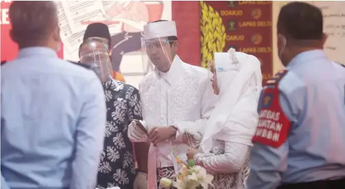  ?? GUSLAN GUMILANG/JAWA POS ?? BAHAGIA: MR, warga binaan kasus penipuan di Lapas Sidoarjo, ketika menjalani akad nikah dengan ASA di aula lantai 2. Akad nikah itu berlangsun­g lancar dengan protokol kesehatan yang ketat.